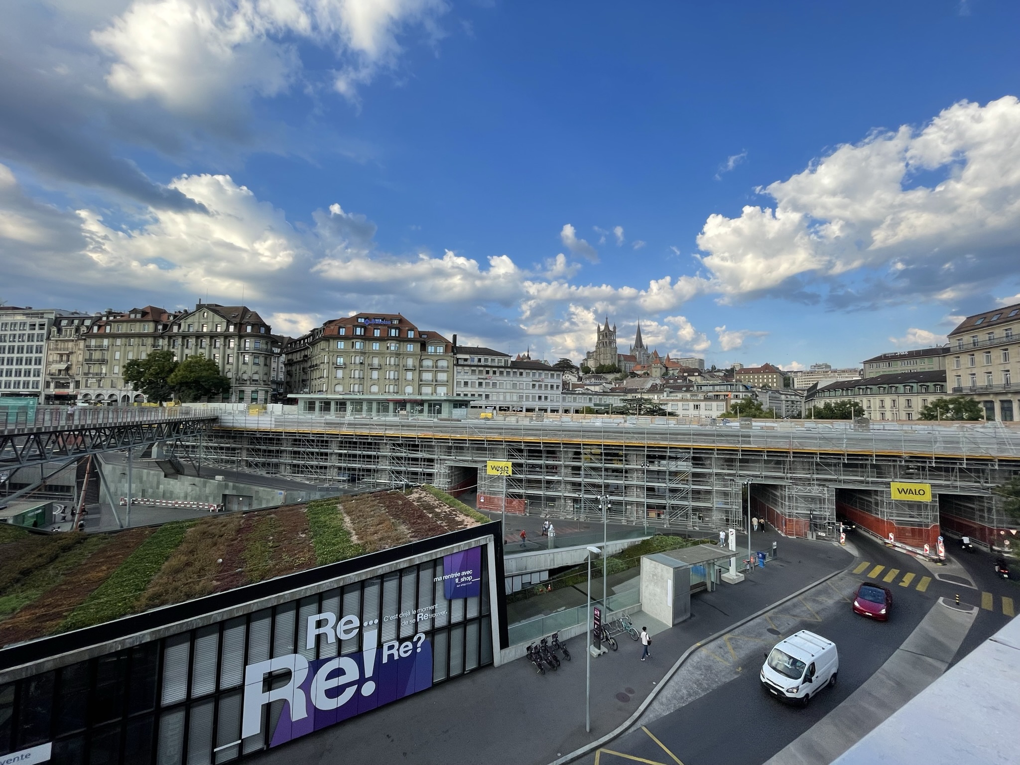 view of Lausanne with a billboard with the word “Re” repeated in a Helvetica-esque typeface