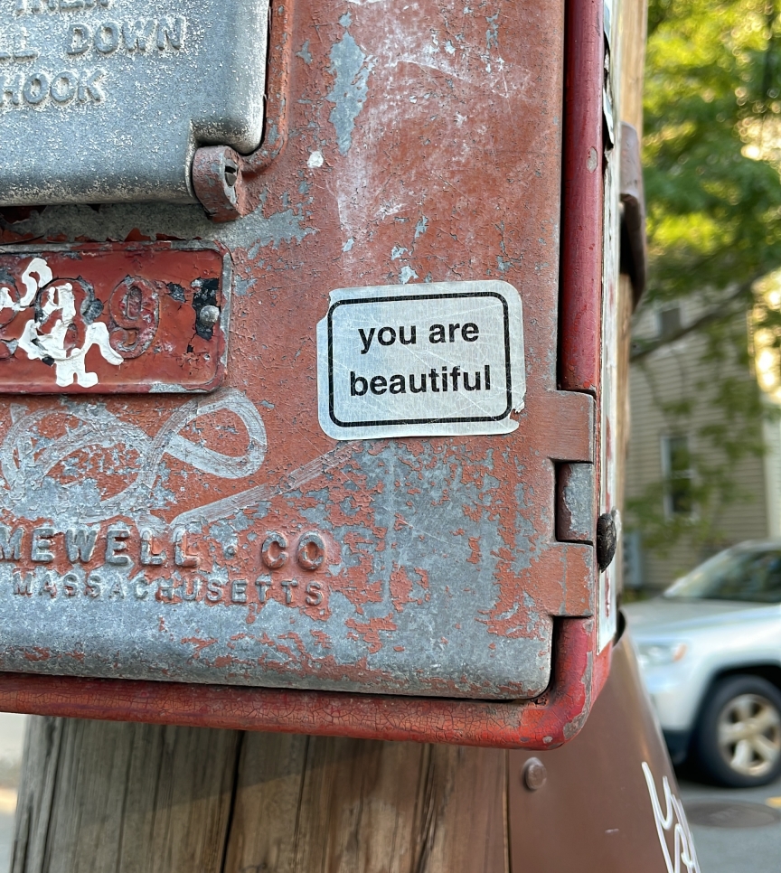 sticker saying "you are beautiful" in Helvetica